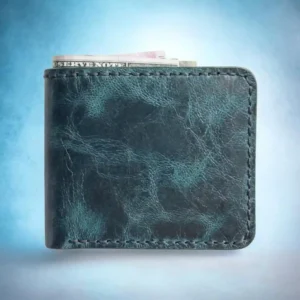 Front view of The Marlin by Indus Hide, a handmade teal distressed leather bifold wallet with unique marbled texture, navy blue hand-stitching, and cash inserted.