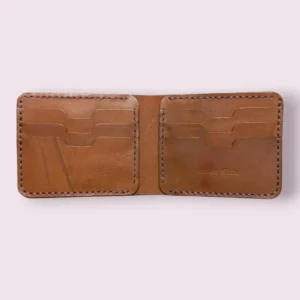 The Caracal by Indus Hide: An interior view of a tan handmade leather bifold featuring 6 precision-cut card slots and authentic hand-saddle stitching.