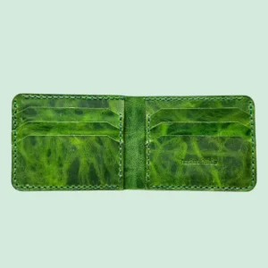 Indus Hide The Basilisk handmade leather bifold wallet open interior showing 6 card slots and full-grain vibrant green pull-up leather grain texture.