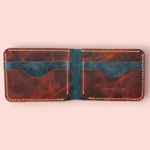Indus Hide The Panthera handmade leather bifold wallet interior showing the reddish brown pull-up leather card slots and dark petrol blue accents with cream hand-stitching.